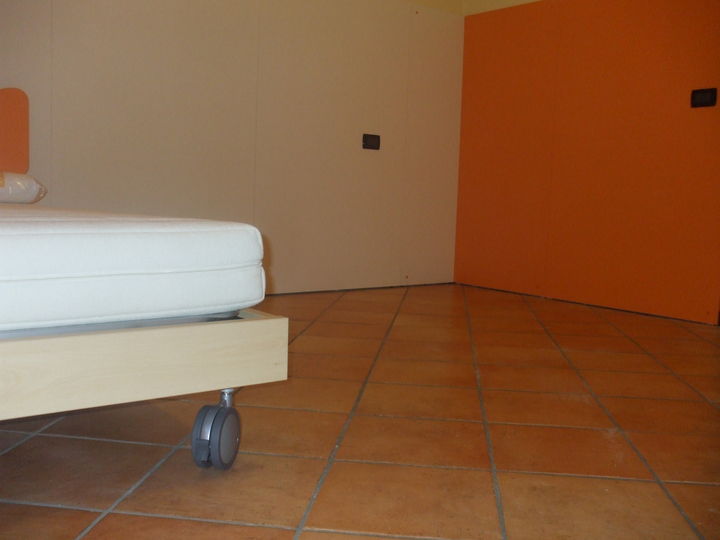 Bellissima cameretta color faggio e arancio con boiserie a muro.
