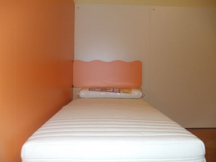 Bellissima cameretta color faggio e arancio con boiserie a muro.