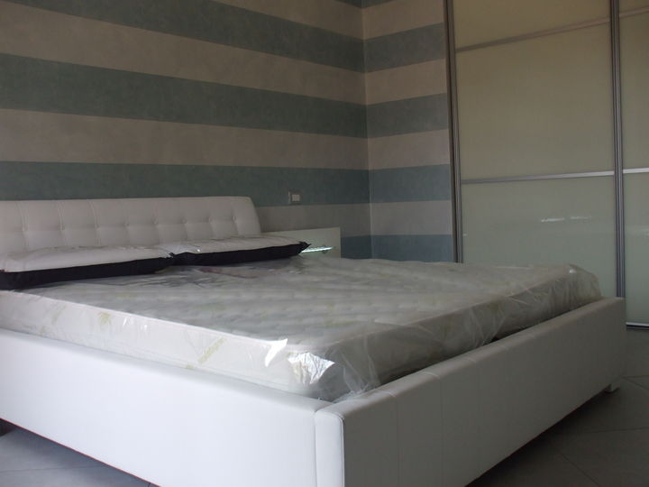 Camera bianco frassinato con letto in ecopelle.