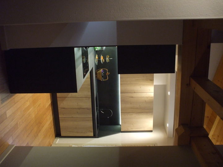 Cucina bicolor con anta in legno grezzo.