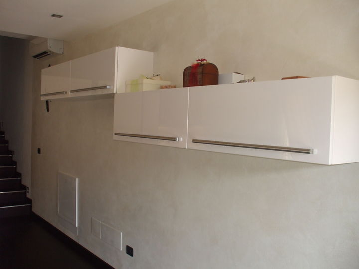 Soggiorno minimalista laccato bianco con elegantissime seggiole in cuoio e bellissimo divano in pelle.